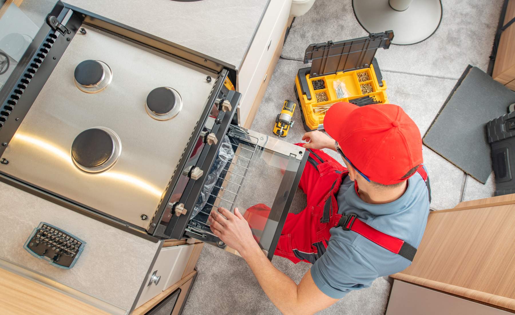 Technician repairing a built-in gas stove appliance