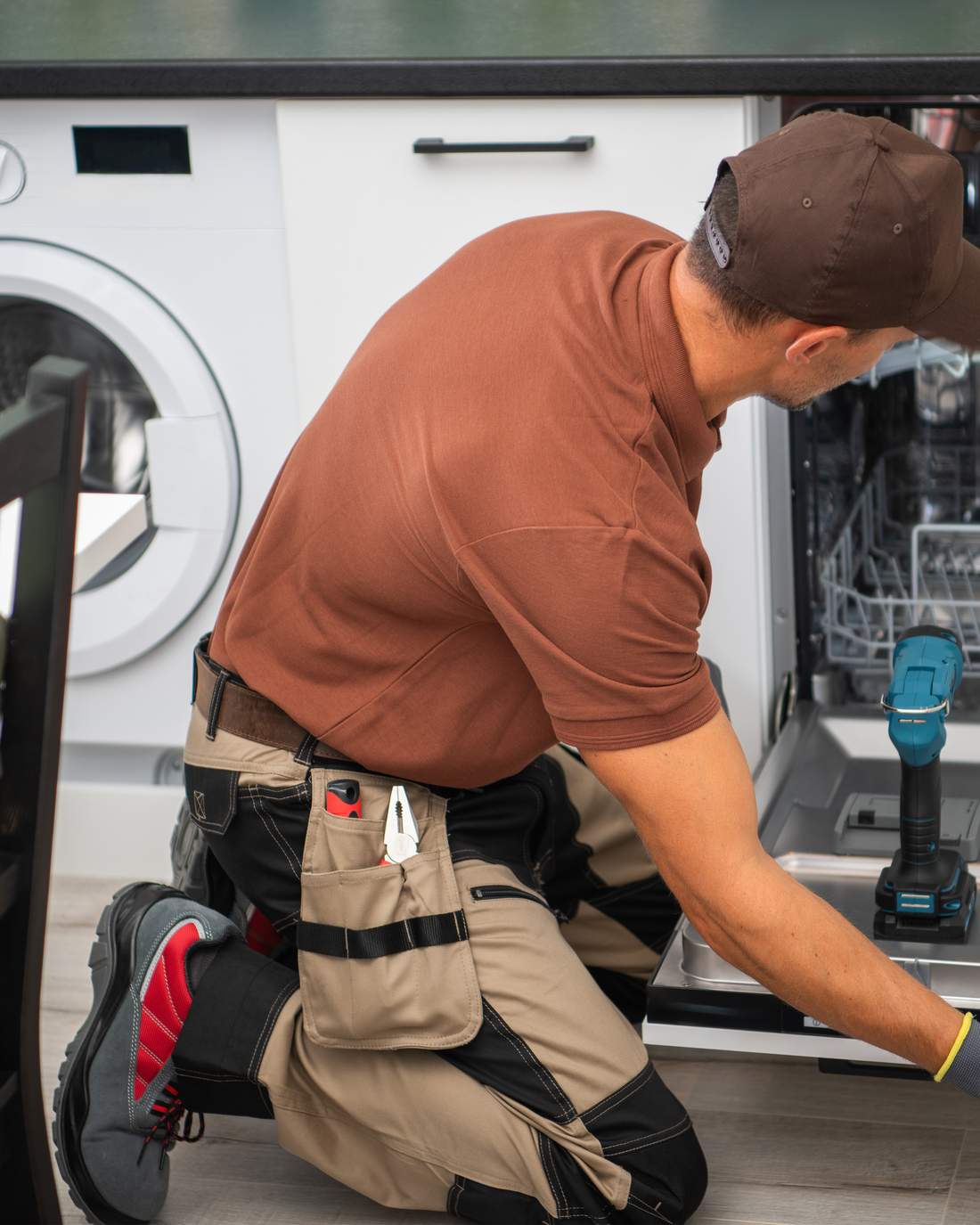 Technician repairing a residential dishwasher appliance